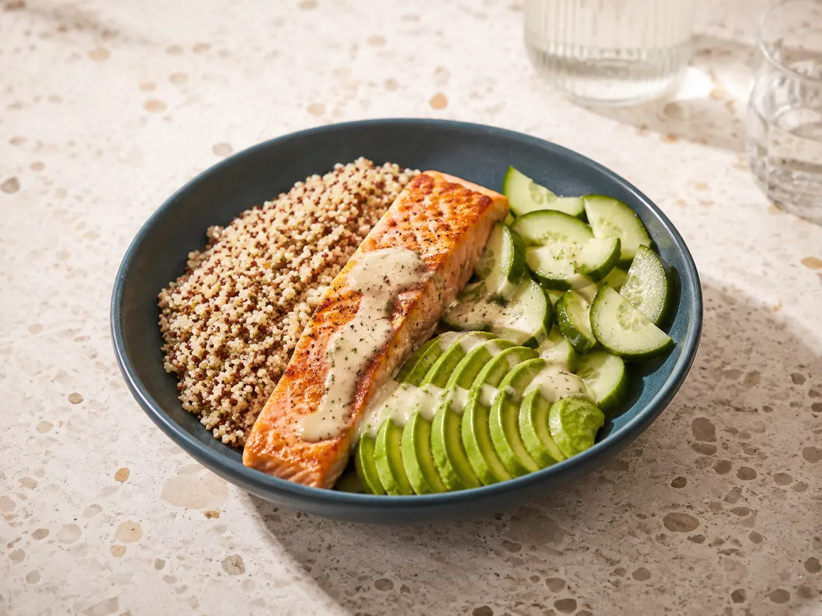 Bowl complet au saumon, quinoa et avocat présenté dans une assiette